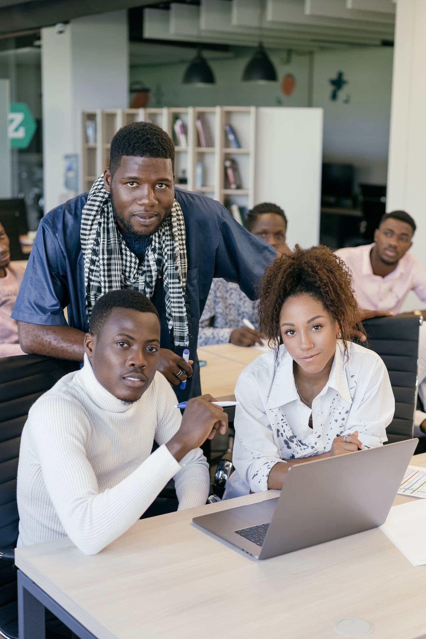 A small team gathered around a laptop discussing a product