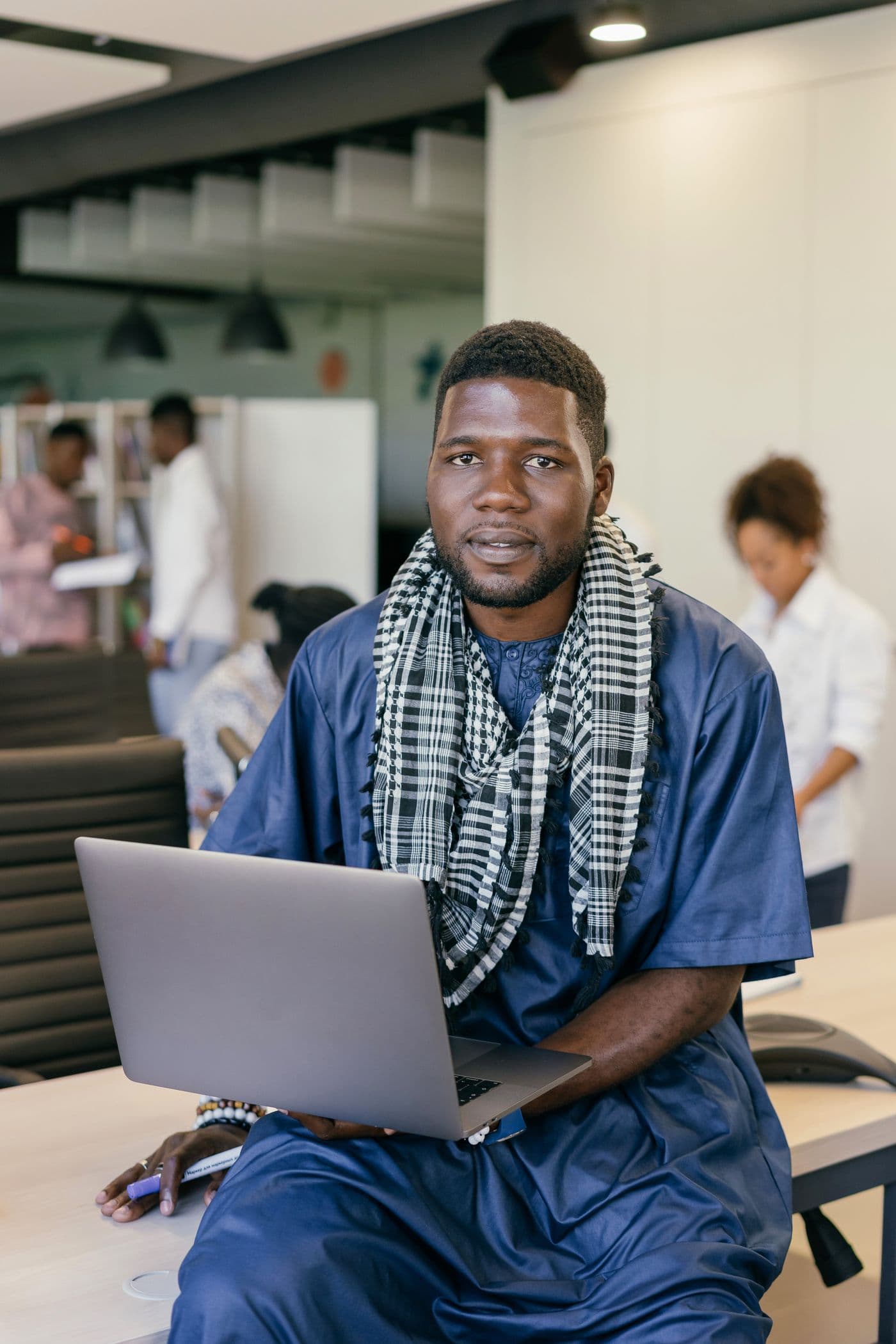 A business owner working on a laptop in a busy office