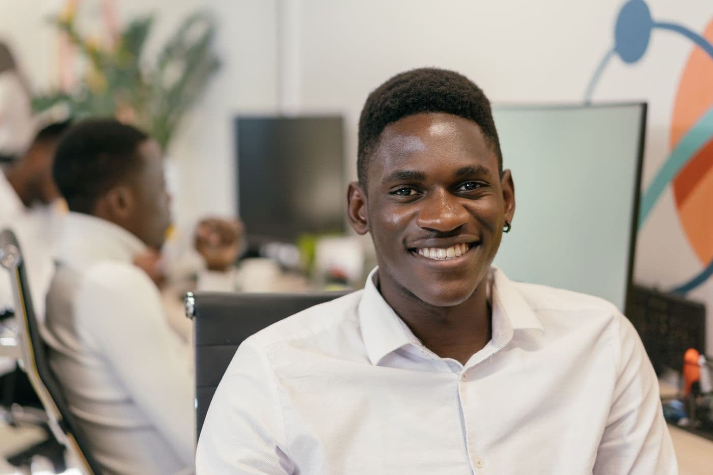 A smiling team member at a desk in a modern office